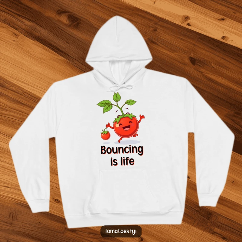 Funny hoodie features a smiling tomato parent playfully bouncing a tiny tomato, radiating warmth and humorous parental affection.