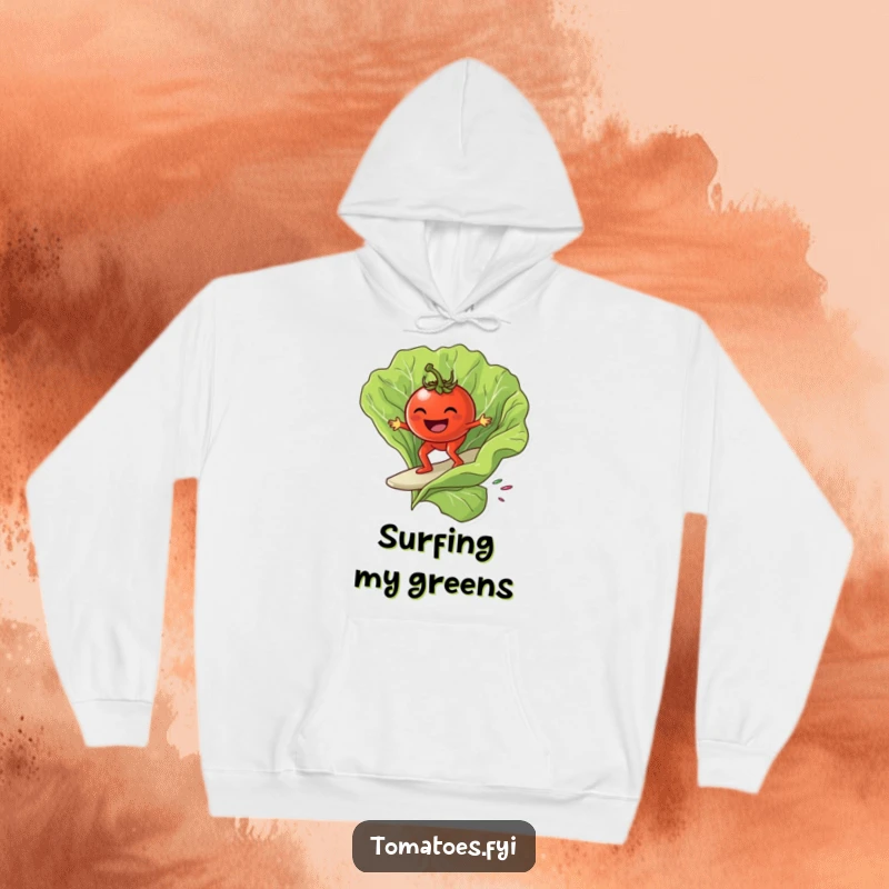 Funny grinning tomato character surfing on a giant lettuce leaf, on a warm and funny hoodie.